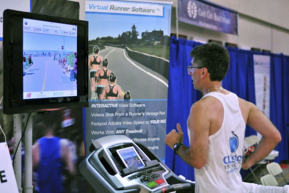 Joe Ciavattone, an employee of Outside Interactive, demonstrates the company's virtual race technology at the New Balance Falmouth Road Race expo. The company is partnering with the race to let runners compete on a treadmill virtually from anywhere while watching video footage of the actual 7-mile course. (Collin Binkley/AP)