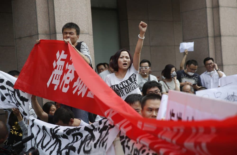 Residents, whose homes were destroyed in the explosion at a chemical warehouse last week, protest outside the hotel where authorities are holding a press conference in Tianjin on August 17, 2015. (STR/AFP/Getty Images)