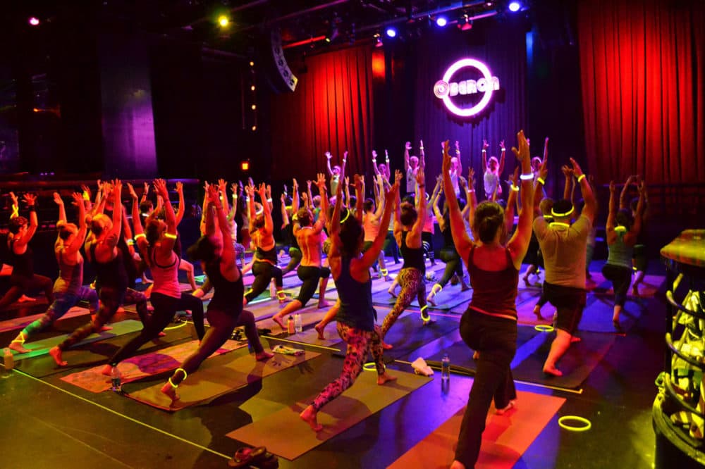 About 50 people participate in 90 minutes of rave yoga at the Oberon in Cambridge on Aug. 5. (Photo by Alexandra Düsterfeld; Courtesy Bill Connolly of Move With)