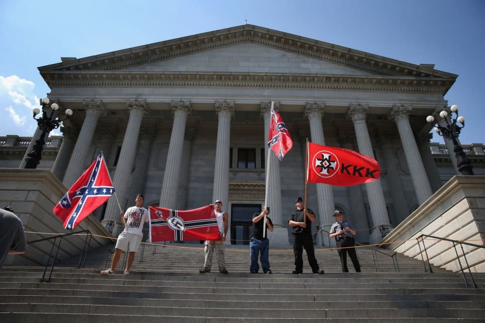 Ku Klux Klan members take part in a Klan demonstration at the state house building on July 18, 2015 in Columbia, South Carolina. The KKK protested the removal of the Confederate flag from the state house grounds and hurled racial slurs at minorities as law enforcement tried to prevent violence between the opposing groups.  (John Moore/Getty Images)