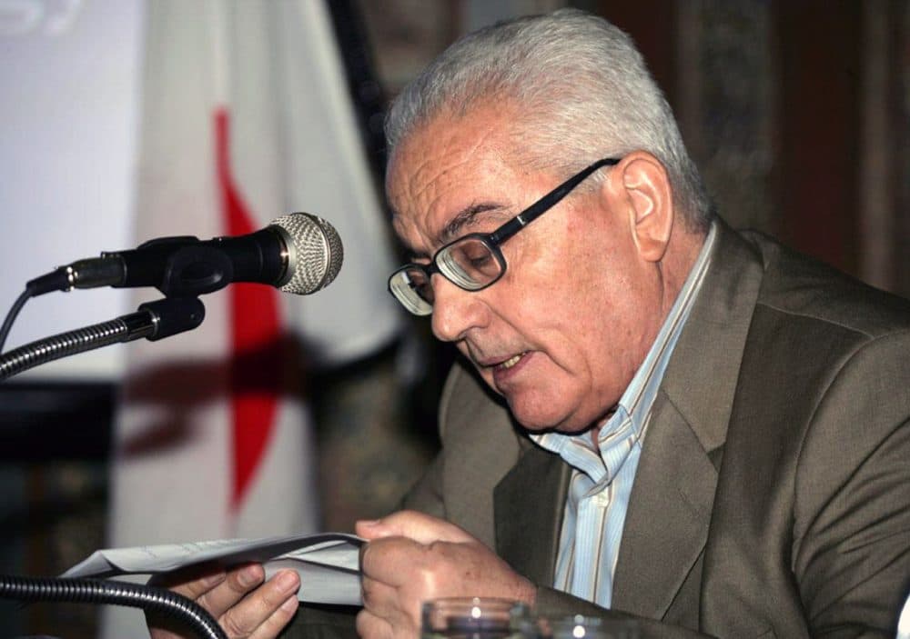 In this undated photo released Tuesday, Aug. 18, 2015 by the Syrian official news agency SANA, one of Syria's most prominent antiquities scholars, Khaled al-Asaad, speaks in Syria. Islamic State militants beheaded al-Asaad in the ancient town of Palmyra, Syria, then strapped his body to one of the town's Roman columns, Syrian state media and an activist group said Wednesday. The killing of 81-year-old al-Asaad was the latest atrocity perpetrated by the militant group, which has captured a third of both Syria and Iraq. (SANA via AP)