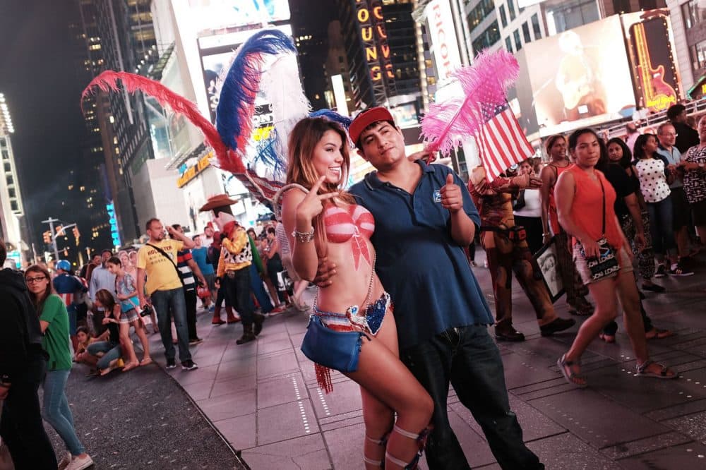 A semi-nude model poses for a photo in Times Square on August 19, 2015, in New York City. As the iconic Times Square continues to draw tourists with its entertaining and carnival-like atmosphere, New York Mayor Bill de Blasio has announced that the city is preparing to address the issue of topless and painted women who pose for pictures while soliciting tips. In recent years, Times Square has seen an influx of performers who dress in a variety of costumes and sometimes become aggressive with the public. The semi-nude women, who call themselves desnudas, Spanish for naked, and pose for photos in exchange for tips, are a new addition to the colourful environment. (Spencer Platt/Getty Images)