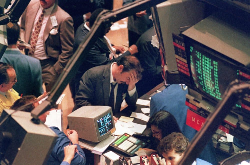 A picture taken on October 19, 1987, shows a trader holding his head on the floor of the New York Stock Exchange when the Dow Jones dropped over 500 points, as panic selling swept Wall Street. (Maria Bastone/AFP/Getty Images)