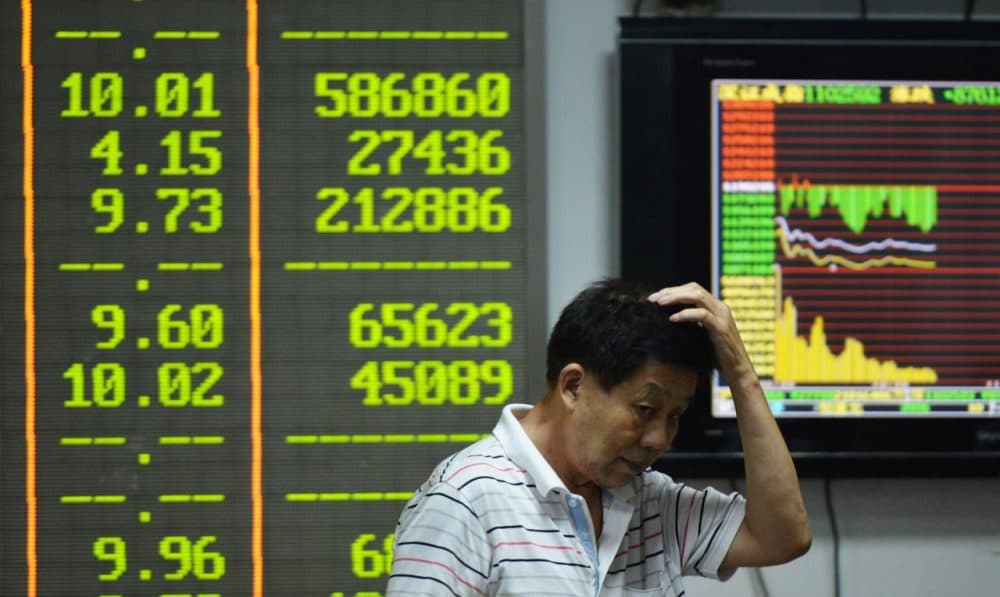 An investor gestures in front of screens showing share prices at a securities firm in Hangzhou, in eastern China's Zhejiang province on August 24, 2015. Shanghai shares nosedived 8.49 percent on August 24 as Beijing's latest market intervention failed to restore confidence, with concern mounting about the stalling economy (STR/AFP/Getty Images)