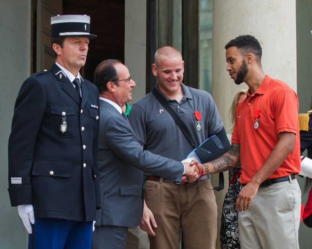 French President Francois Hollande, left, shakes hands with Anthony Sadler, right, a senior at Sacramento University in California, while U.S. Airman, Spencer Stone, looks on as they leave the Elysee Palace in Paris, France, after being awarded with the French Legion of Honor by French President,  Monday, Aug. 24, 2015.  (Kamil Zihnioglu/AP Photo)