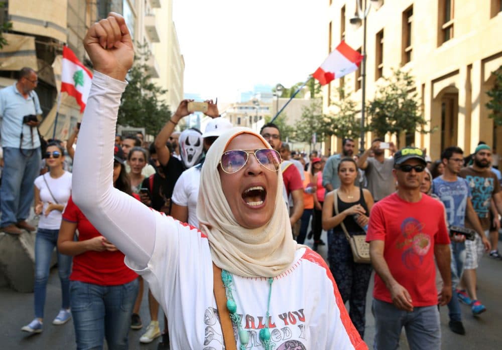 A Lebanese activist chants slogans during a protest against the ongoing trash crisis, in downtown Beirut, Lebanon, Sunday, Aug. 23, 2015. Thousands of protesters poured into central Beirut Sunday demanding government resignation hours after Prime Minister Tammam Salam hinted he might step down following violent protests against government corruption and political dysfunction triggered by a month long trash crisis in Beirut. (Bilal Hussein/AP Photo)