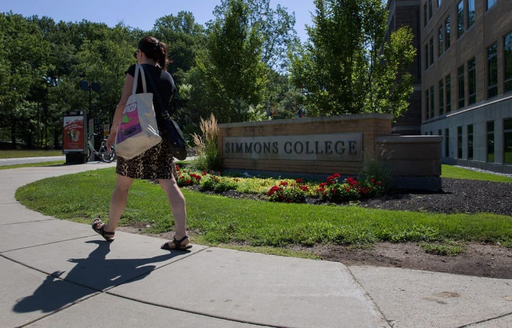 A woman walks by Simmons College campus. (Hadley Green for WBUR)