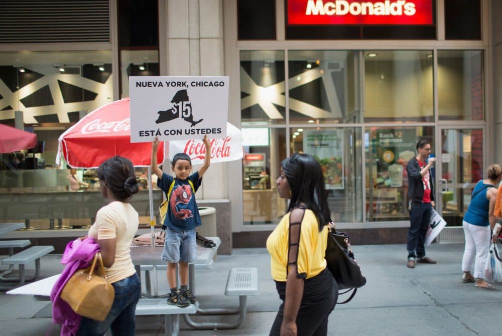 Juan Hernandez, 8, protests with his mother, who works for McDonald's, and other fast food workers and community activists outside a McDonald's restaurant in the Loop on June 22, 2015 in Chicago, Illinois. The protesters were calling for an increase in the minimum wage to $15 per hour. The demonstration was staged to coincide with the 4th hearing of the Wage Board in New York City as it debates the $15-dollar-per-hour increase for its workers. (Scott Olson/Getty Images)