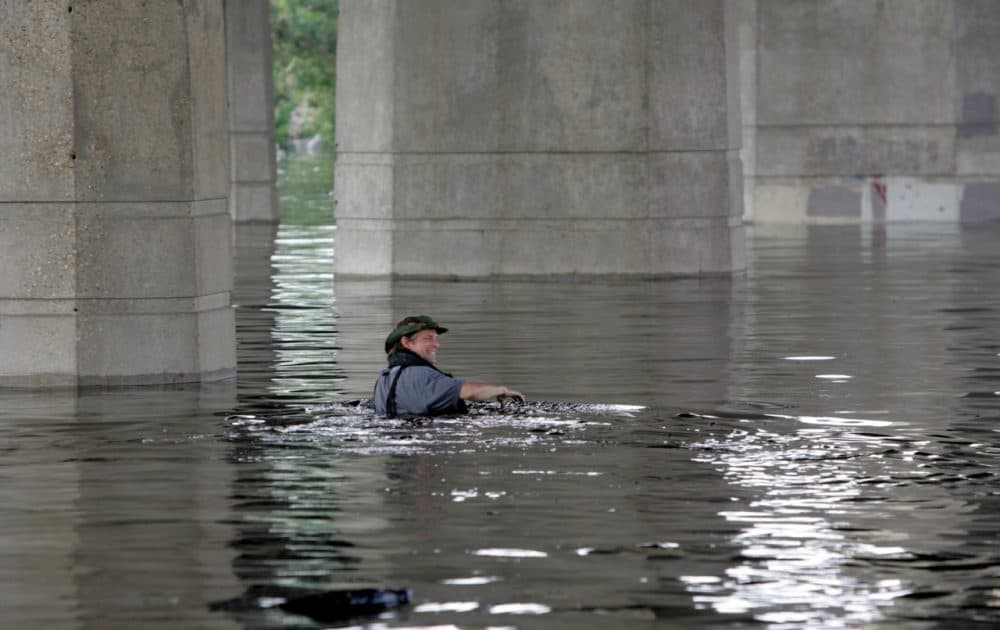 Times-Picayune staff photographer Alex Brandon swims away from the paper in the flooded city of New Orleans during the aftermath of Hurricane Katrina on Tuesday, Aug. 30, 2005. Brandon had swam to the building to get a memory card of photos to the paper. (Bill Haber/AP)
