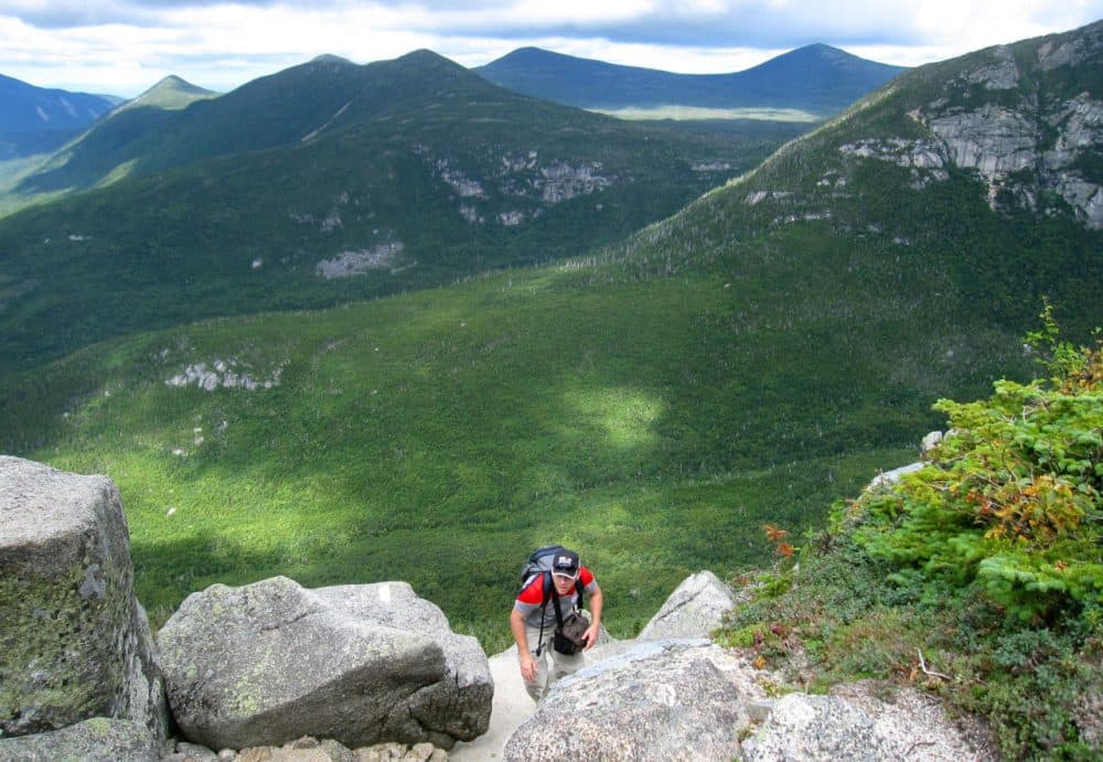 A hiker climbs up Mount Katahdin with the wilderness of Baxter State Park in Maine in the background, Aug. 27, 2014. Katahdin is nearly a mile high, the tallest mountain in Maine, and its peak is the northern terminus of the Appalachian Trail. (Beth J. Harpaz/AP)