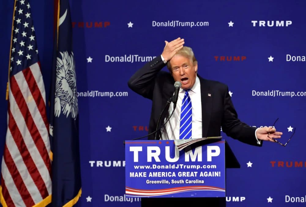 Republican presidential candidate Donald Trump pulls his hair back to show that it is not a toupee while speaking during a rally at the TD Convention Center Thursday in Greenville, S.C. (Richard Shiro/AP)