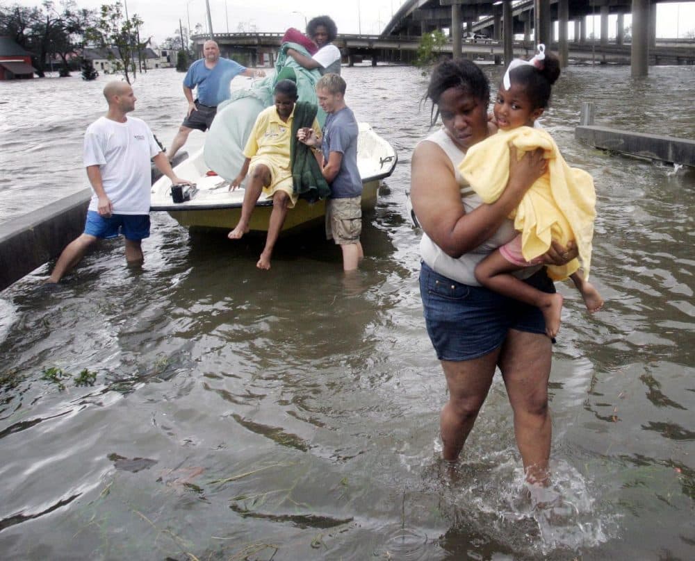 Shante Gruld carries Janeka Garner, 5, to safety after they were rescued from their flooded home by boat in New Orleans, Monday morning, Aug. 29, 2005. (Eric Gay/AP)