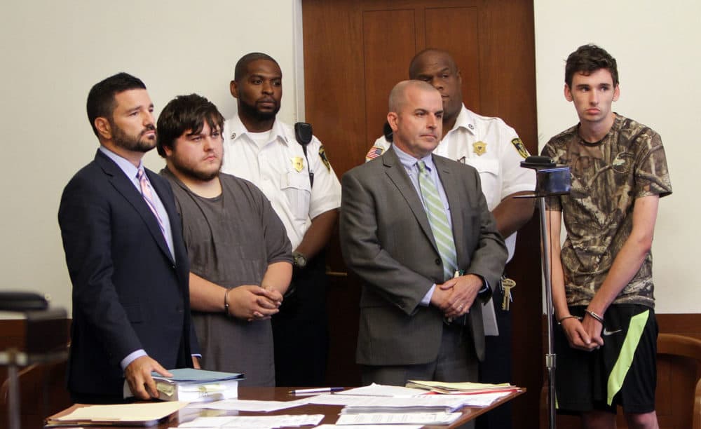 James Stumbo, second from left, and Kevin Norton, right, stand during their arraignment at Boston Municipal Court on Aug. 24 with their lawyers. They were arrested on firearms charges after allegedly threatening the Pokémon World Championships in Boston. (Chitose Suzuki/Boston Herald via AP, Pool)