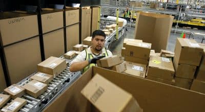 Compared to mistreated workers at under-the-radar small businesses, it can be argued that the threat of bad publicity insulates some corporate employees. In this Nov. 11, 2010 file photo, Ricardo Sandoval places packages in the right shipping boxes at an Amazon.com fulfillment center, in Phoenix. (Ross D. Franklin/ AP)