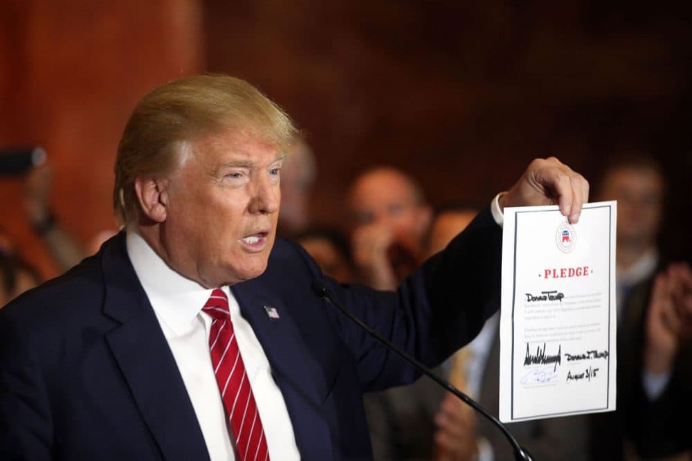 GOP presidential front-runner Donald Trump signs a pledge at a news conference in Manhattan on Thursday to support the Republican nominee in the 2016 general election, ruling out a third-party or independent run.(Spencer Platt/Getty Images)