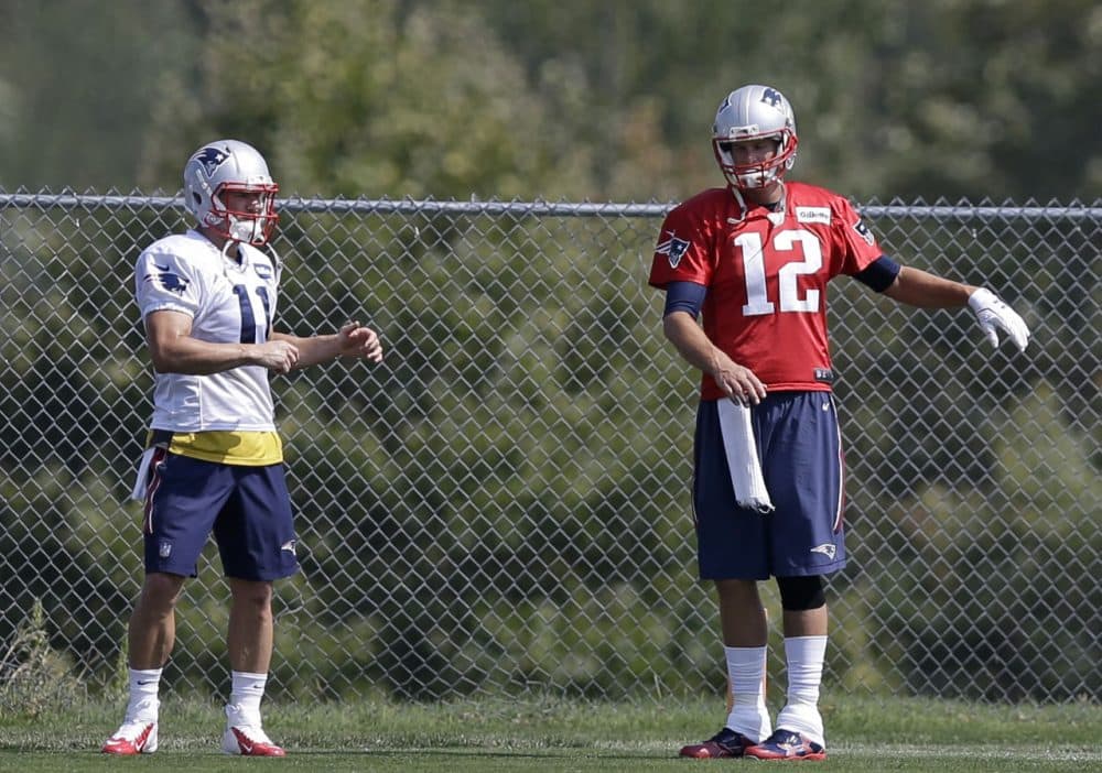 New England Patriots wide receiver Julian Edelman, left, and quarterback Tom Brady, right, stretch as they warm up on the field during an NFL football practice in Foxborough. (Steven Senne/AP)