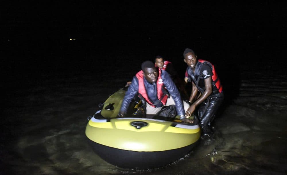 African migrants board a boat to the Greek island of Kos on early August 15, 2015 off the shore of Bodrum, southwest Turkey. Authorities on the island of Kos have been so overwhelmed that the government sent a ferry to serve as a temporary centre to issue travel documents to Syrian refugees - among some 7,000 migrants stranded on the island of about 30,000 people. (Bulent Kilic/AFP/Getty Images)