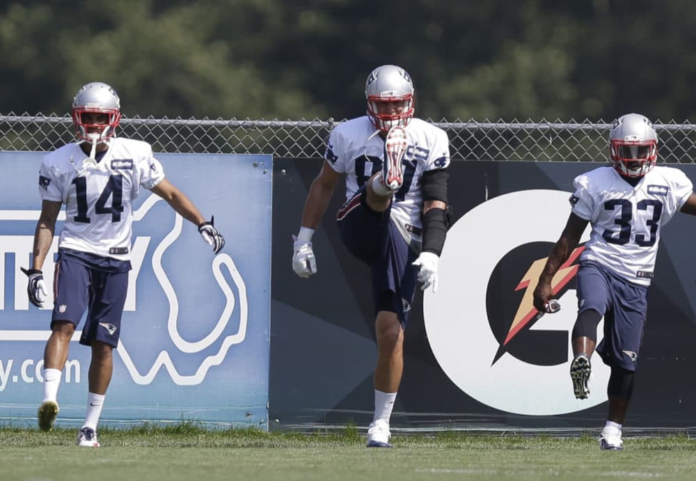 New England Patriots, front the left, wide receiver Chris Harper, tight end Rob Gronkowski, and running back Dion Lewis warm up on the field during an NFL football practice, Tuesday in Foxborough, Mass. (Steven Senne/AP)