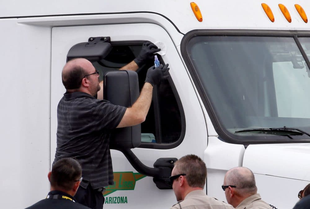 Arizona Department of Public Safety officers inspect a tractor trailer with a bullet hole in the passenger door shortly after it was shot near 67th Ave and I-10, Thursday, Sept. 10, 2015 in Phoenix. Numerous shootings of vehicles along I-10 over the past two weeks have investigators working around the clock to find a suspect in a spate of recent Phoenix freeway shootings that have rattled nerves and heightened fears of a possible serial shooter. (AP Photo/Matt York)