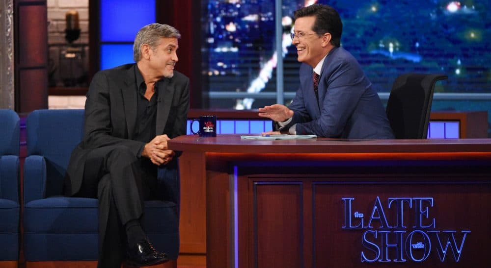 Stephen Colbert, right, talks with actor George Clooney during the premiere episode of &quot;The Late Show,&quot; Tuesday Sept. 8, 2015, in New York. Clooney and Republican presidential candidate Jeb Bush were the guests for Colbert's debut. (Jeffrey R. Staab/CBS via AP)