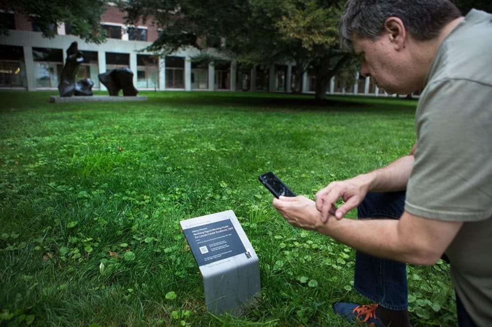 MIT List Visual Arts Center social media coordinator Mark Linga demonstrates how a QR reader plays an audio file on his phone that corresponds to a piece of art. (Jesse Costa/WBUR)