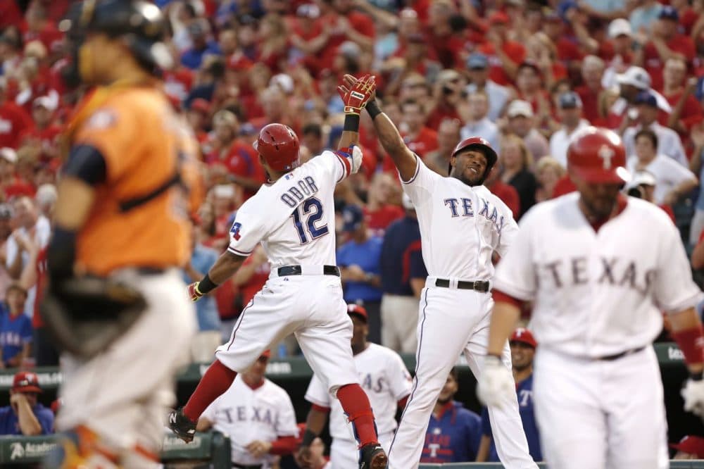 Rougned Odor #12 of the Texas Rangers is congratulated by Elvis Andrus after hitting a two run home run during the first inning of a baseball game against the Houston Astros at Globe Life Park on September 16, 2015 in Arlington, Texas. (Brandon Wade/Getty Images)