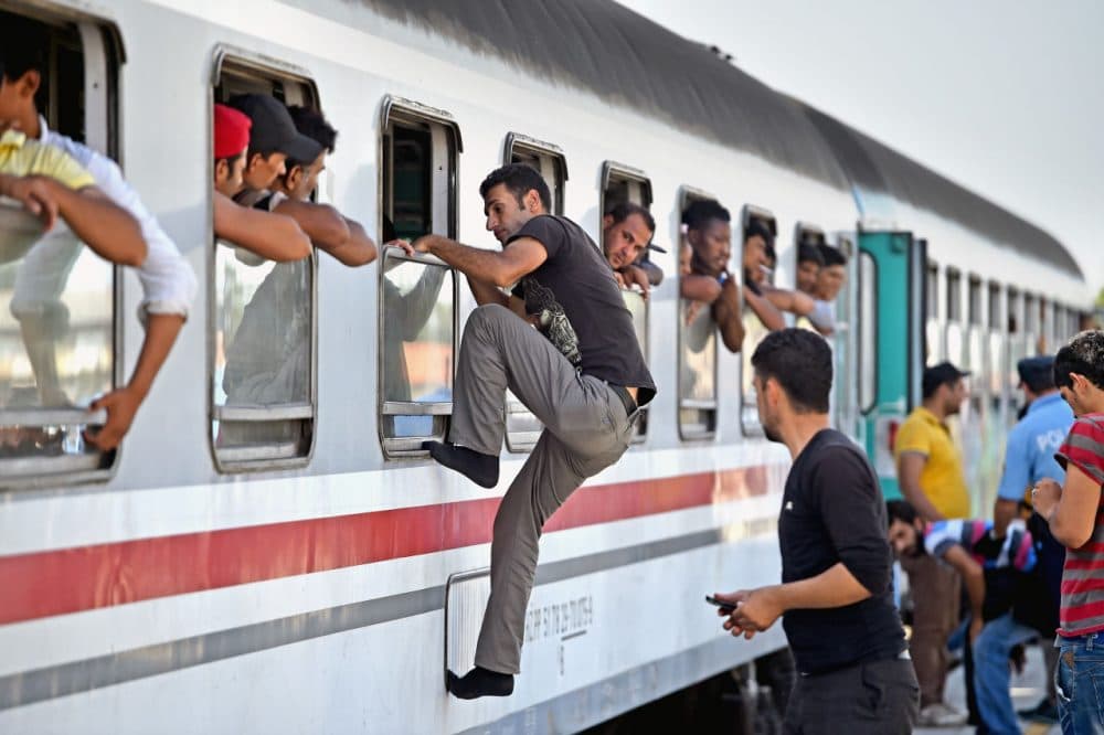 Migrants climb through windows to board trains at the train station in Beli Manastir, near the Hungarian border on Friday in Beli Manastir, Croatia. (Jeff J. Mitchell/Getty Images)