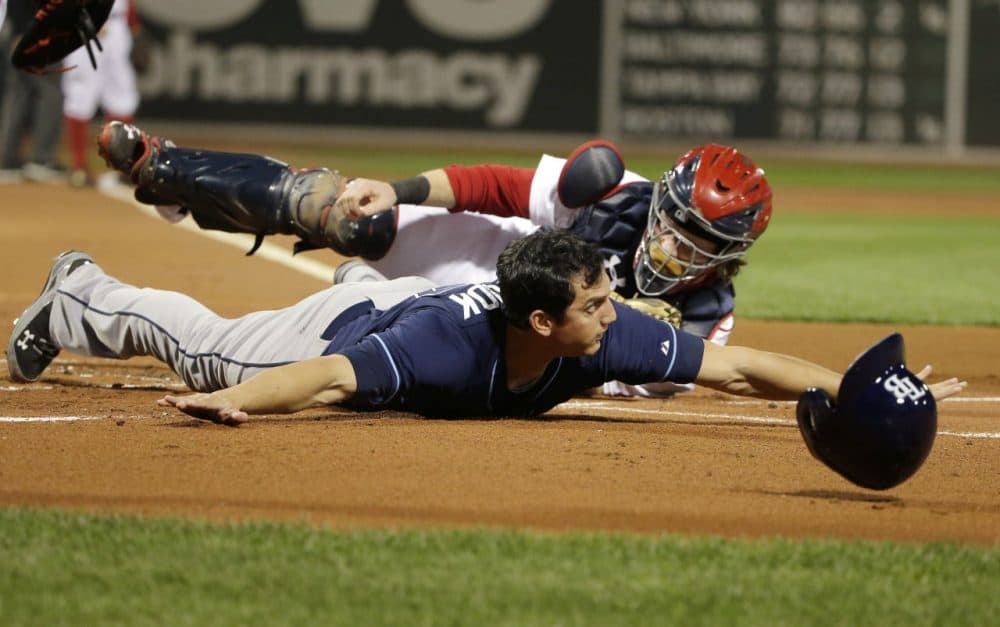 Tampa Bay Rays' Mikie Mahtook, left, slides safe at home plate as Boston Red Sox catcher Ryan Hanigan, right, tries to tag him in the first inning of a baseball game, Monday, Sept. 21, 2015, at Fenway Park, in Boston. (Steven Senne/AP)