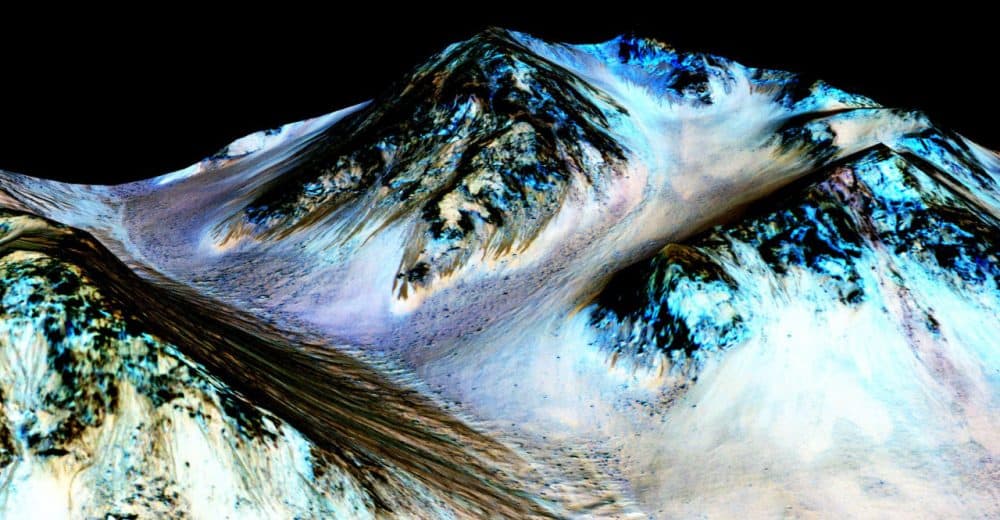 These dark, narrow, 100 meter-long streaks called recurring slope lineae flowing downhill on Mars are inferred to have been formed by contemporary flowing water. (Courtesy NASA/JPL/University of Arizona)