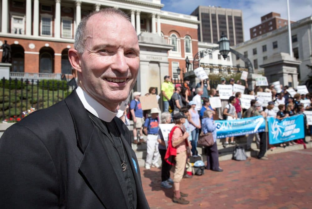 The Reverend Fred Small stands outside the State House in Boston Tuesday morning with other climate change activists. (WBUR / Robin Lubbock)