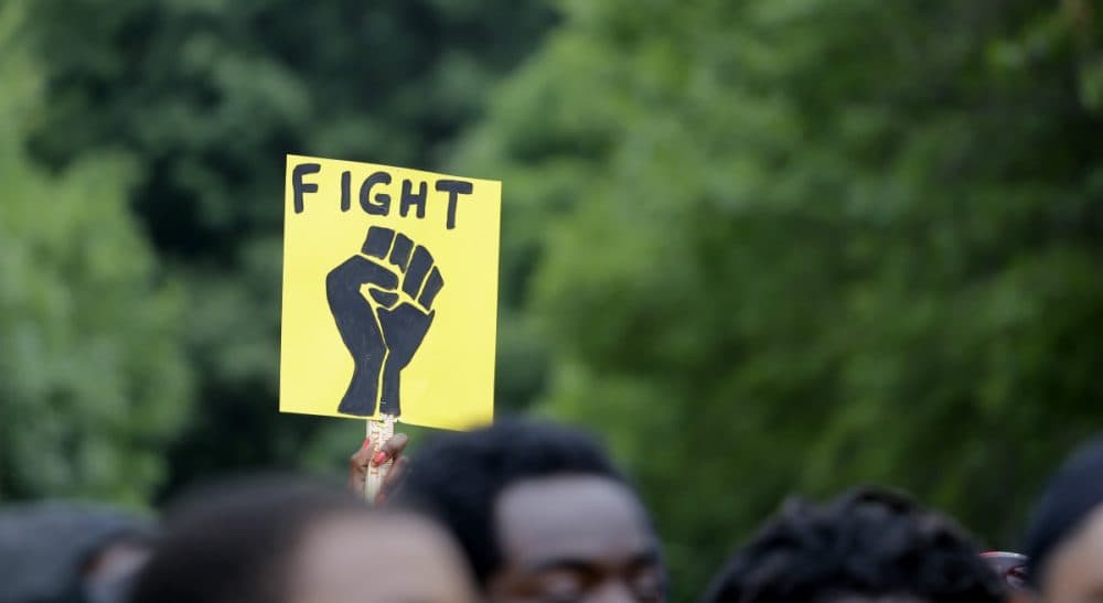 A woman holds up a sign as hundreds take part in a march in memory of VonDerrit Myers Jr., on Saturday, Aug. 8, 2015, in St. Louis. Myers, a black 18-year-old shot and killed last October by an off-duty St. Louis police officer. The city prosecutor in May announced the officer acted in self-defense after being fired upon by Myers while an attorney for Myers' family says Myers was not armed. (Jeff Roberson/AP)
