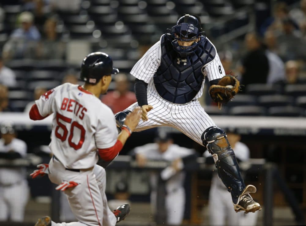 Boston Red Sox's Mookie Betts (50) tries to score as New York Yankees catcher John Ryan Murphy drops to the plate after catching a high throw on a first-inning fielder's choice in New York Monday. (Kathy Willens/AP)