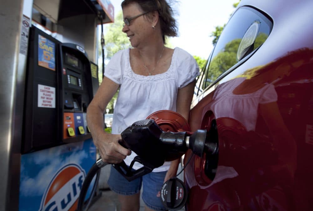 A woman from Walpole, Mass. fills up her car at a Gulf station in Brookline.  (Steven Senne/AP)