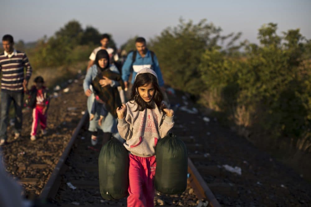 Syrian refugees make their way on a railway track after crossing the border between Serbia and Hungary in Roszke, southern Hungary. Many migrants are searching for another country to resettle in. (AP Photo/Muhammed Muheisen)