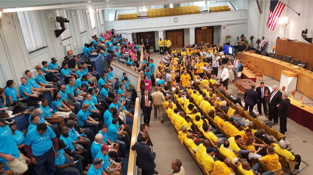 Uber drivers in blue, taxi drivers in yellow, and Lyft drivers in pink packed into the Gardner Auditorium to hear four bill proposals on ride-hailing companies. (Courtesy of Gintautas Dumcius)