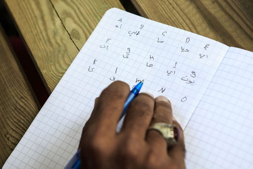 A refugee learns the letters of the German language taught by a volunteer in a garden of a private initiative near the refugee camp on August 29, 2015 in Dresden, Germany. Germany is expecting to receive 800,000 migrants this year and is struggling to cope with the record number. Germany is currently struggling to accommodate and process a record-number of asylum seekers from the Middle East, Africa and the Balkans.  (Carsten Koall/Getty Images)