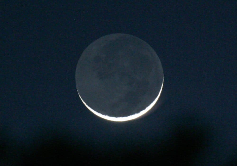 A thin waxing crescent moon is seen just after sunset, in Tyler, Texas on Friday, Feb. 8, 2008. The nightside of the moon is lit by reflected light from the dayside of the earth and is known as earthshine. (Dr. Scott M. Lieberman/AP)