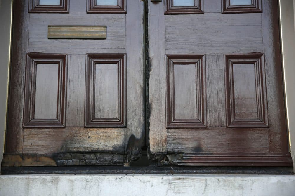 Fire-damaged rectory doors at the 173-year-old Shrine of St. Joseph church that were damaged by an arsonist are shown Thursday, Oct. 22, 2015, in St. Louis. The fire, set early Thursday morning, marks the seventh time in two weeks someone ignited doors outside a place of worship in St. Louis or one of its suburbs, police said. (Jeff Roberson/AP)
