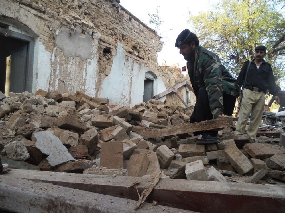 A Pakistani policeman digs through the debris of collapsed houses after an earthquake in Kohat on October 26, 2015. A powerful 7.5 magnitude earthquake killed at least 70 people as it rocked south Asia, including 12 Afghan girls crushed to death in a stampede as they tried to flee their collapsing school. (Basit Shah/AFP/Getty Images)