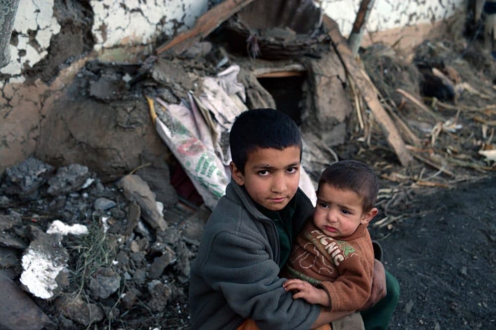 A Pakistani boy holds his young brother in the rubble of collapsed houses in the quake-hit village of Gandao around 20 kilometers from Shangla in Pakistan's Khyber Pakhtunkhwa province on October 27, 2015. Rescuers were picking their way through rugged terrain and pockets of Taliban insurgency in the search for survivors after a massive quake hit Pakistan and Afghanistan, killing more than 350 people. The toll was expected to rise as search teams reach remote areas that were cut off by Monday's powerful 7.5 magnitude quake, which triggered landslides and stampedes as it toppled buildings and severed communication lines. (Sajjad Qayyum/AFP/Getty Images)