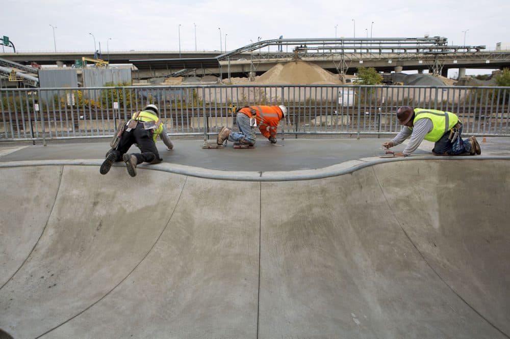 After more than a decade of planning, the Lynch Family Skatepark will open in November, giving local skaters a large scale place to skate. Pictured: Workers laid cement for the skate park in Cambridge. (Jesse Costa/WBUR)