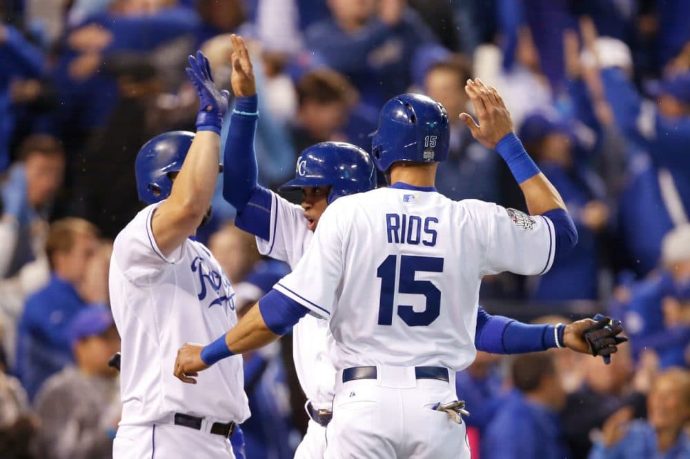 Alcides Escobar #2 of the Kansas City Royals and Alex Rios #15 of the Kansas City Royals celebrate with Kendrys Morales #25 of the Kansas City Royals after scoring runs in the fifth inning against the New York Mets in Game Two of the 2015 World Series at Kauffman Stadium on October 28, 2015 in Kansas City, Missouri. (Sean M. Haffey/Getty Images)
