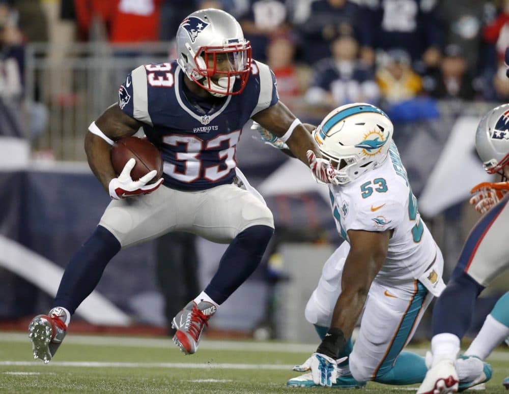 Patriots running back Dion Lewis (33) evades Miami Dolphins outside linebacker Jelani Jenkins (53) in Thursday night's game. (Michael Dwyer/AP)