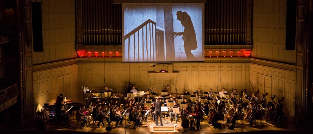 The Boston Pops rehearse a score created by Berklee College of Music for the iconic 1922 silent film “Nosferatu: A Symphony of Horror,” as the movie plays above the stage. (Courtesy Elizabeth Friar)