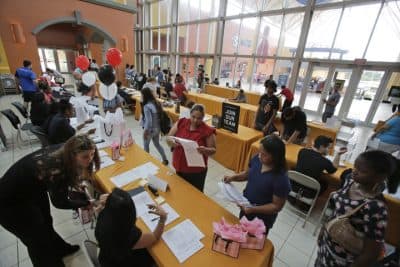 In this Tuesday, Oct. 6, 2015 photo, job applicants fill out and turn in forms during a job fair at Dolphin Mall in Miami. (AP)