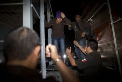 In this Aug. 29, 2014 file photo, immigration officials remove Central American migrants from a northbound freight train during an after midnight raid by federal police in San Ramon, Mexico. Following a surge in child migrants reaching the U.S. border in 2014, Mexican authorities said Tuesday, March 3, 2015 that they staged more than 150 raids over the last year on the train known as &quot;La Bestia&quot; that rolled toward the U.S. border. (AP)