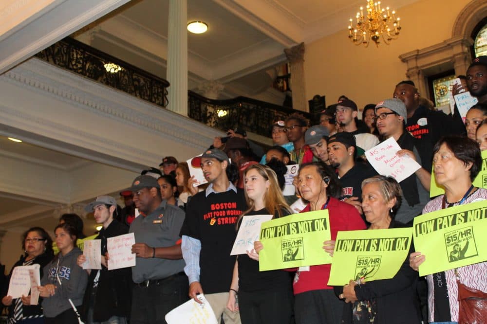 Dozens of fast food workers rallied at the State House Tuesday to urge lawmakers to boost the minimum wage to $15 an hour by 2018 and to support bills they say would make scheduling fairer for employees. (Antonio Caban/SHNS)