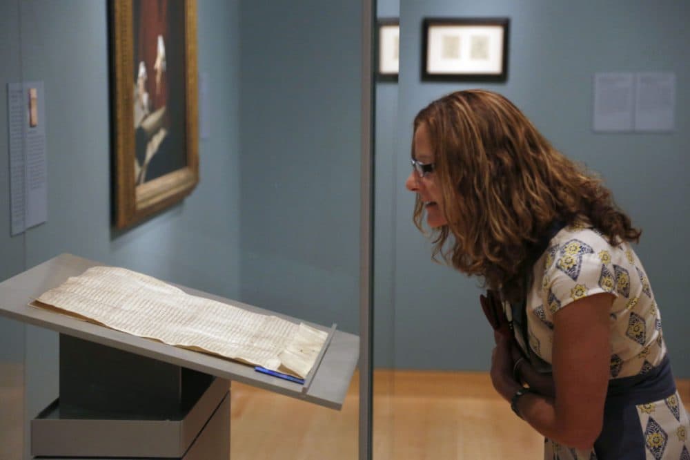 Museums are trying many new ways to get visitors into the galleries. A woman looks an original copy of the Magna Carta when it came to the MFA in Boston in 2014.  (AP Photo/Steven Senne)
