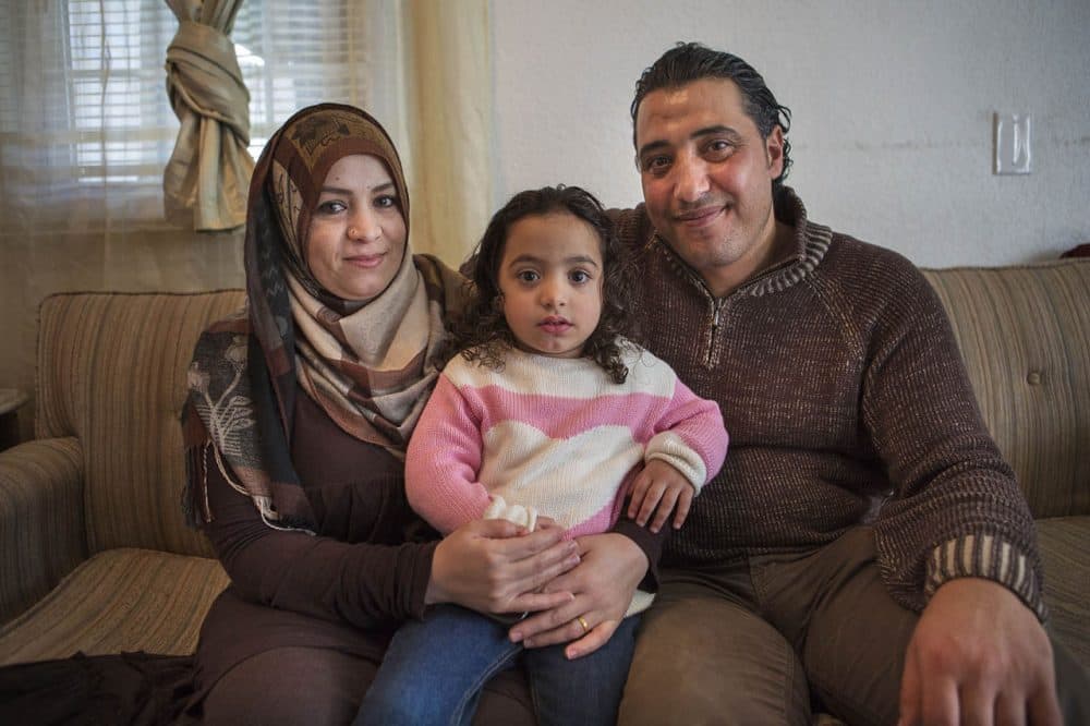 A year ago, Zenab Al-Nassar, left, and her husband, Zid, who are Syrian, were resettled as refugees in western Massachusetts. They're seen here with a daughter, Tuka, in their home in Westfield. (Jesse Costa/WBUR)