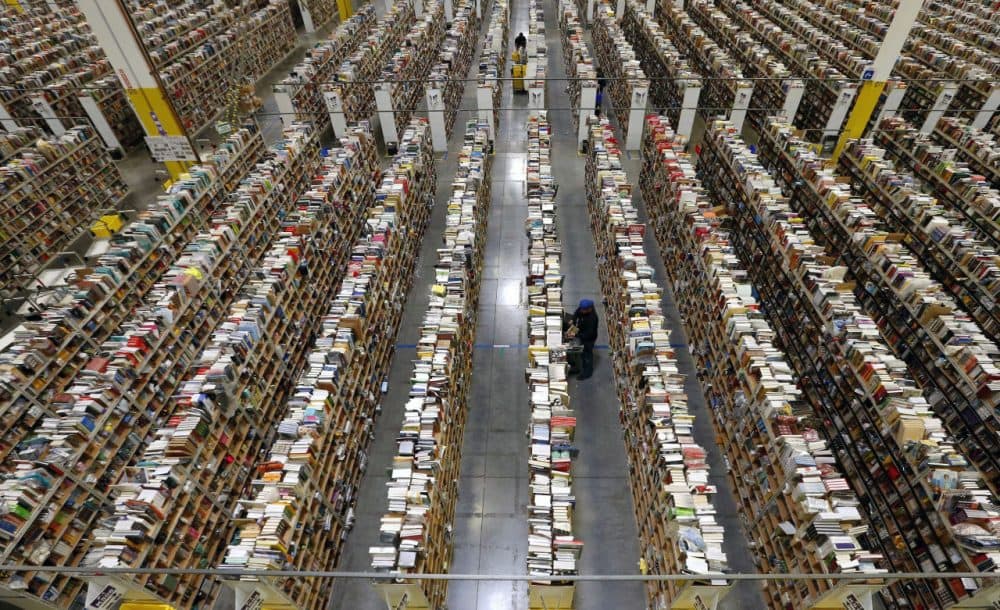 An Amazon.com employee stocks books along one of the many miles of aisles at an Amazon.com Fulfillment Center in Phoenix on December 2, 2013. Amazon just opened its first brick and mortar store in Seattle today. (Ross D. Franklin/AP Photo)